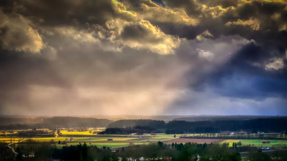 Sommerlandschaft in dramatischer Vorgewitterbeleuchtung mit heftiger Bewölkung und durchdringenden Sonnenstrahlen